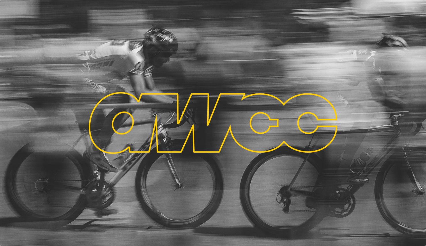 Black-and-white motion-blurred shot of cyclists racing, overlaid with the outlined yellow AWCC wordmark