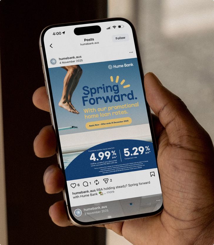 Hand holding a phone showing Hume Bank’s Spring Forward home loan rates Instagram post