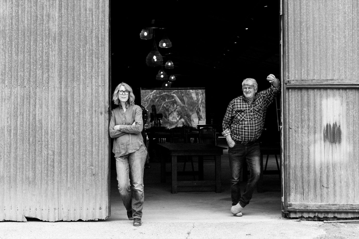 Unposed black-and-white portrait of the Grays in the doorway of a corrugated-iron farm shed